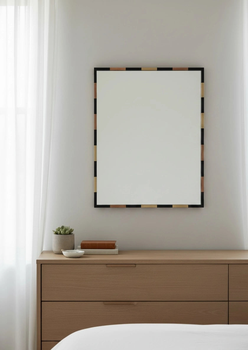 Wooden dresser with a mirror and decorative items against a white wall.